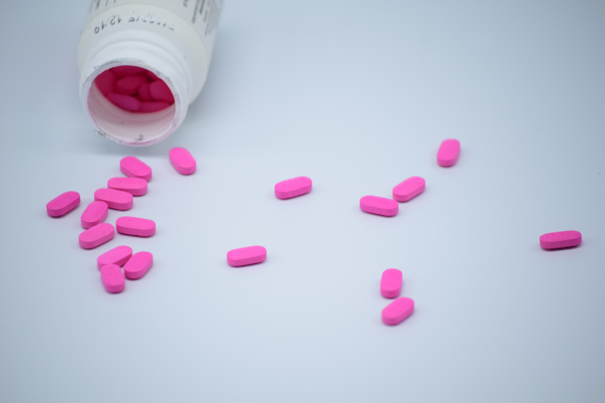 pink Benadryl tablets on a white table